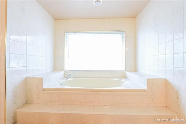 a bathroom with a bathtub and a window