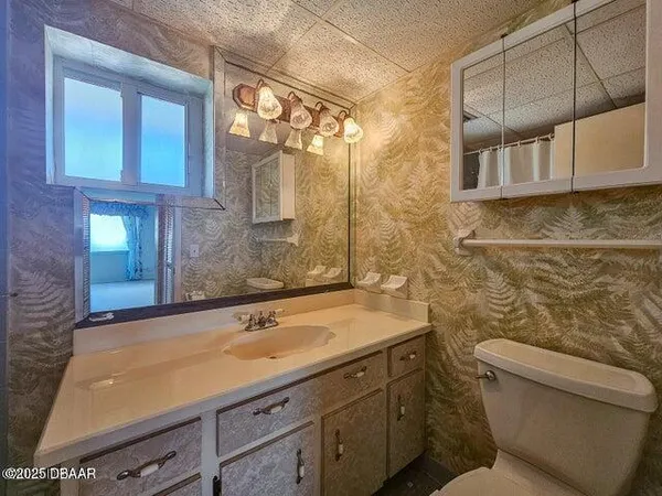 a bathroom with a granite countertop sink a toilet and mirror