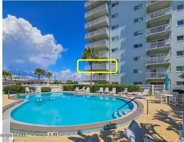 a swimming pool with outdoor seating and yard