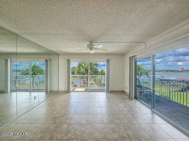 a view of an empty room with wooden floor and a balcony