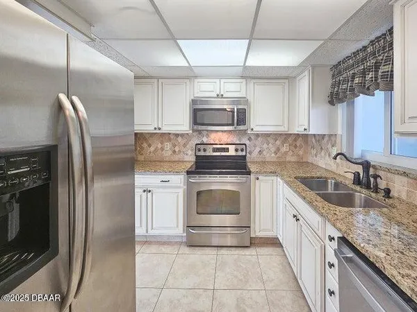 a kitchen with stainless steel appliances granite countertop a stove a sink and a refrigerator
