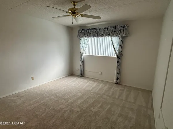 en empty room with windows and fan