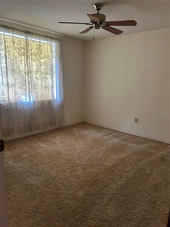 8511 Longboat Lane Hudson, FL 34667 - Photo 12 of 17 en empty room with windows and ceiling fan