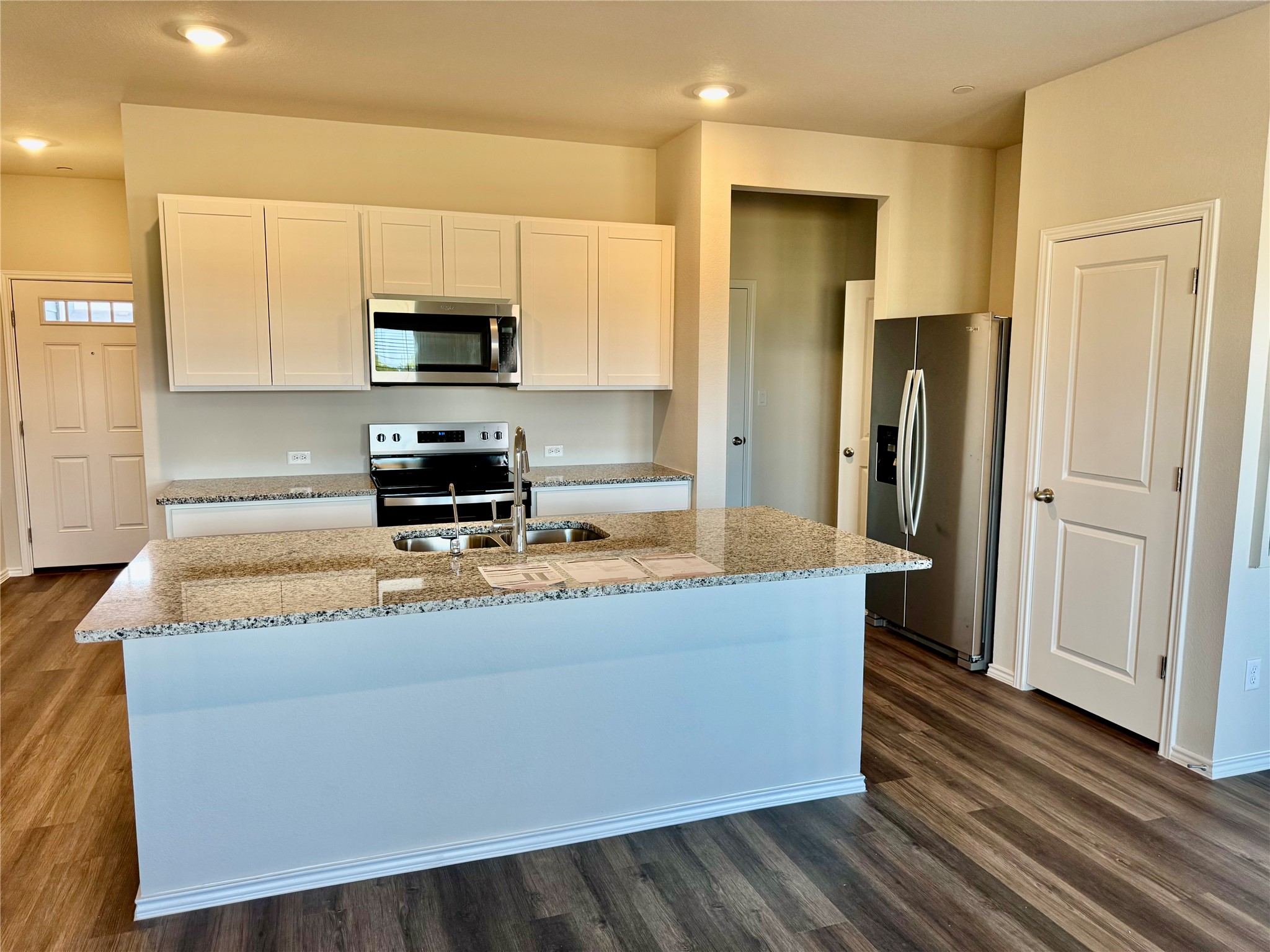 134 Cinnabar Lane, Unit 3 Kyle, TX 78640 - Photo 2 of 7 a kitchen with stainless steel appliances granite countertop a refrigerator a stove and a sink