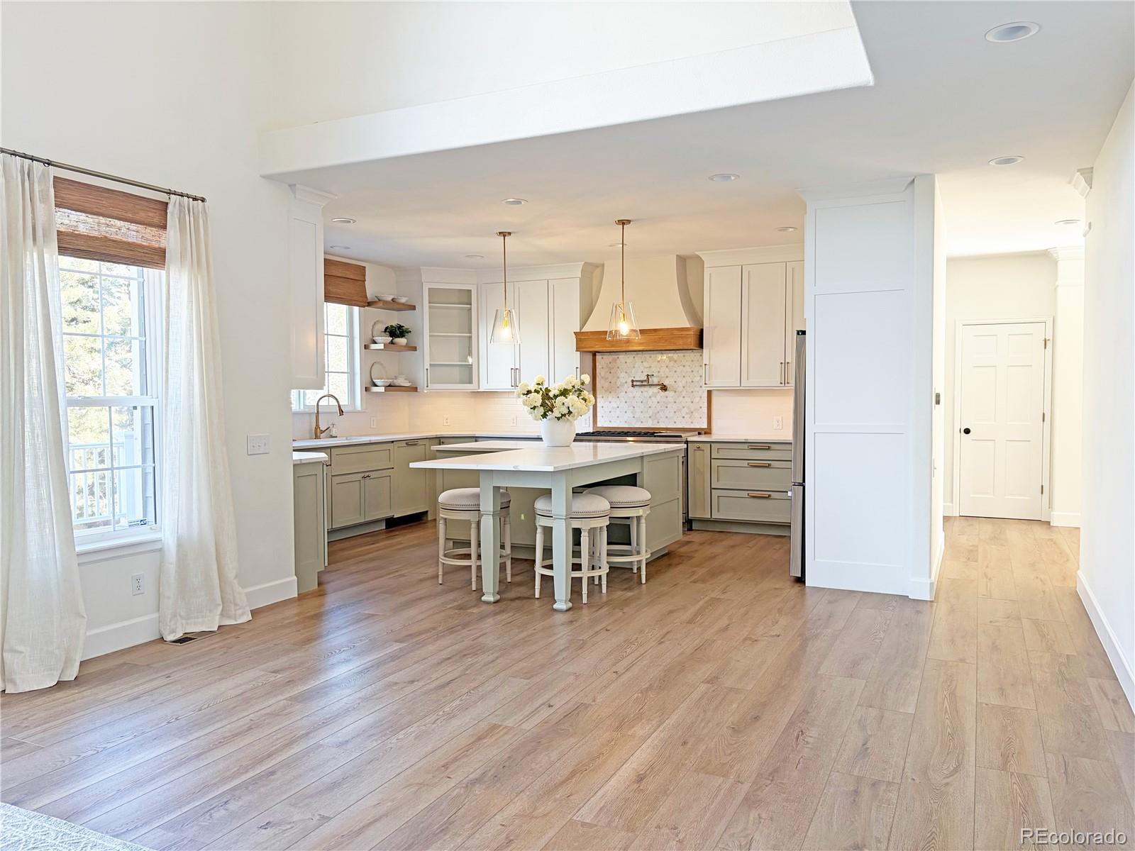 369 Shoreham Circle Castle Pines, CO 80108 - Photo 12 of 41 a kitchen with stainless steel appliances a dining table chairs stove and wooden floor