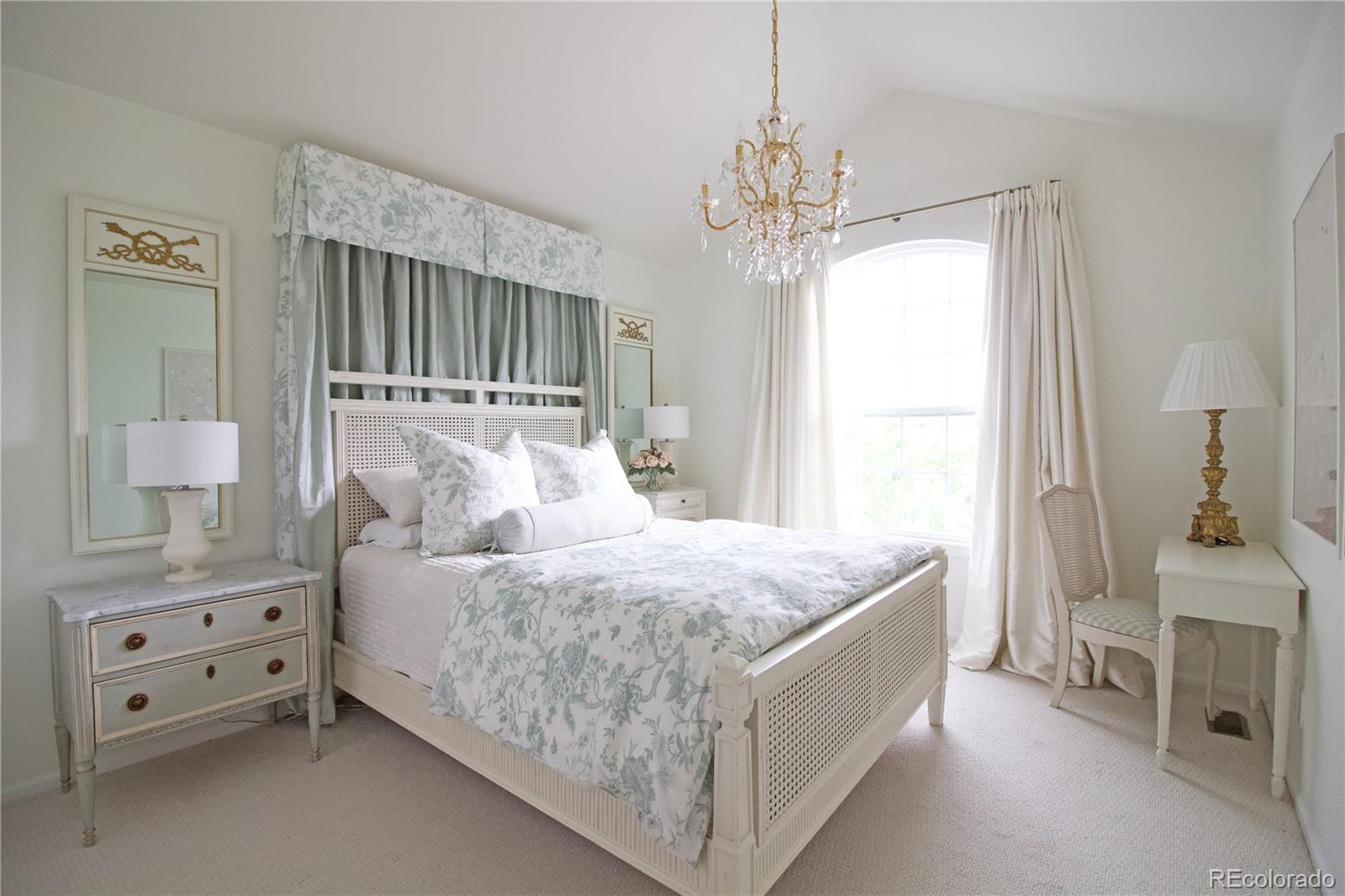 369 Shoreham Circle Castle Pines, CO 80108 - Photo 24 of 41 a bedroom with a bed and a chandelier