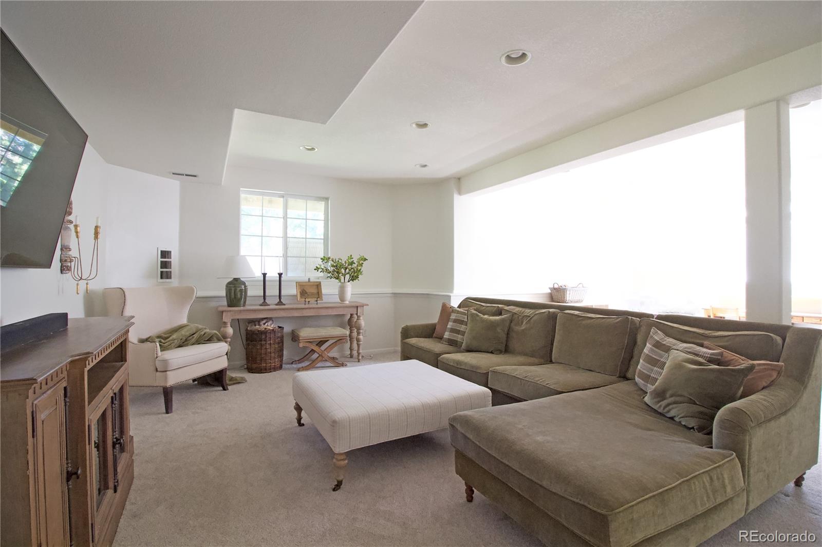 369 Shoreham Circle Castle Pines, CO 80108 - Photo 30 of 41 a living room with furniture and a large window