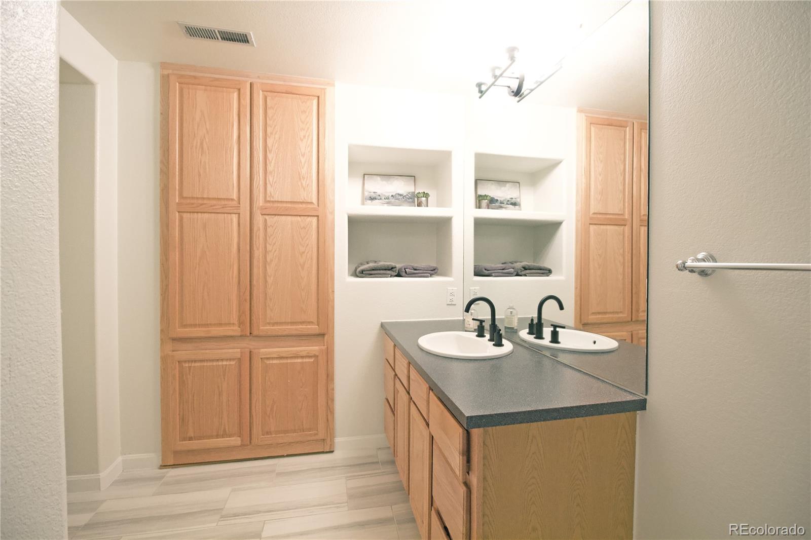 369 Shoreham Circle Castle Pines, CO 80108 - Photo 34 of 41 a bathroom with a sink and a mirror