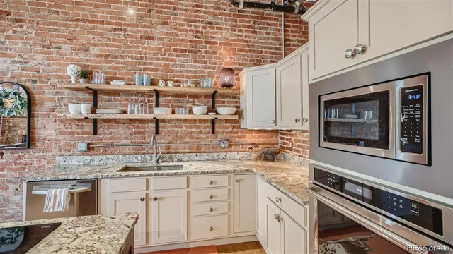 a kitchen with granite countertop a sink stove and refrigerator