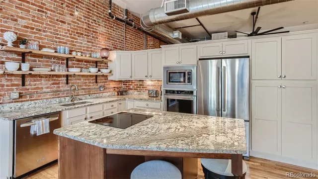 a kitchen with granite countertop cabinets stainless steel appliances and a counter space