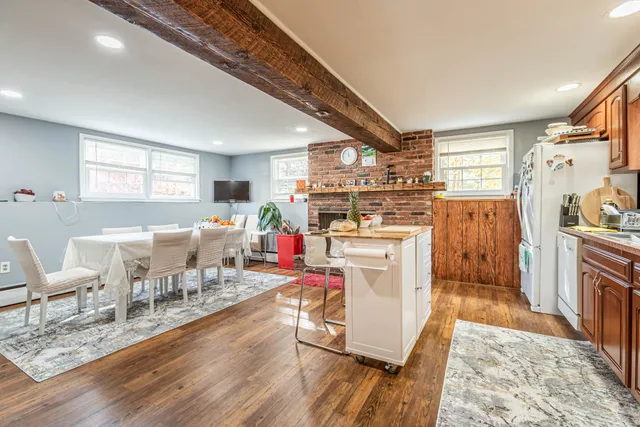 a living room with furniture appliances and wooden floor