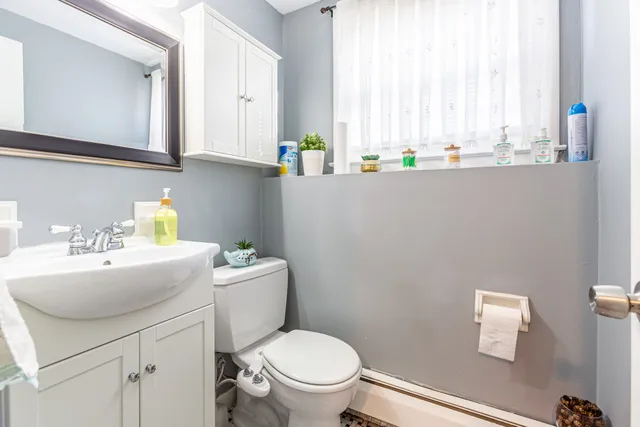 a bathroom with a sink a toilet and a window