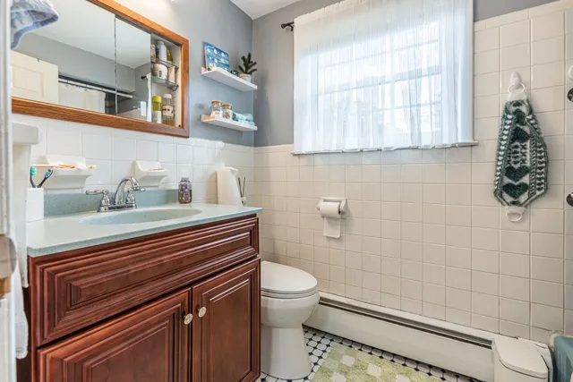 a bathroom with a sink a toilet and a window