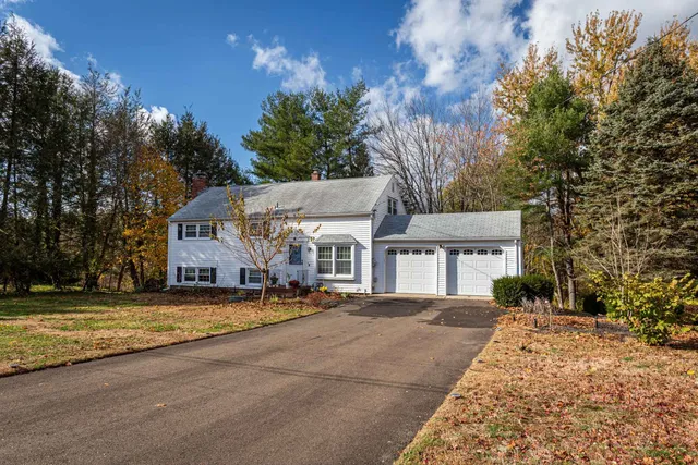 a view of a house with a big yard and large trees