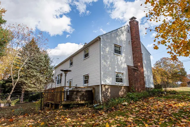a backyard of a house with table and chairs