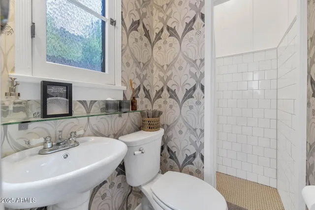 a bathroom with a sink a toilet and shower curtain
