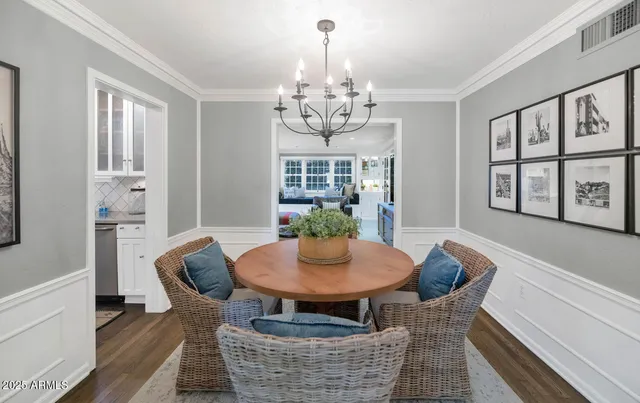 a dining room with furniture a chandelier and wooden floor