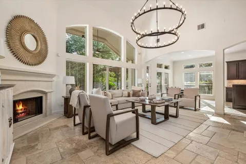 a living room with furniture a fireplace and a floor to ceiling window