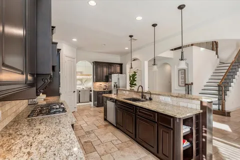 a kitchen with a sink refrigerator and cabinets