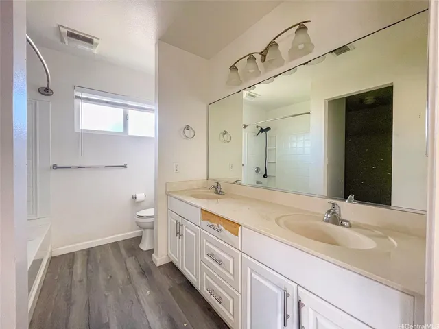 a spacious bathroom with a granite countertop sink mirror and a toilet