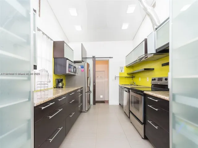 a kitchen with stainless steel appliances granite countertop a sink a stove and a refrigerator