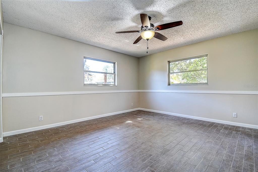 808 Helmsman Way Palm Harbor, FL 34685 - Photo 13 of 27 a view of an empty room with wooden floor and a window