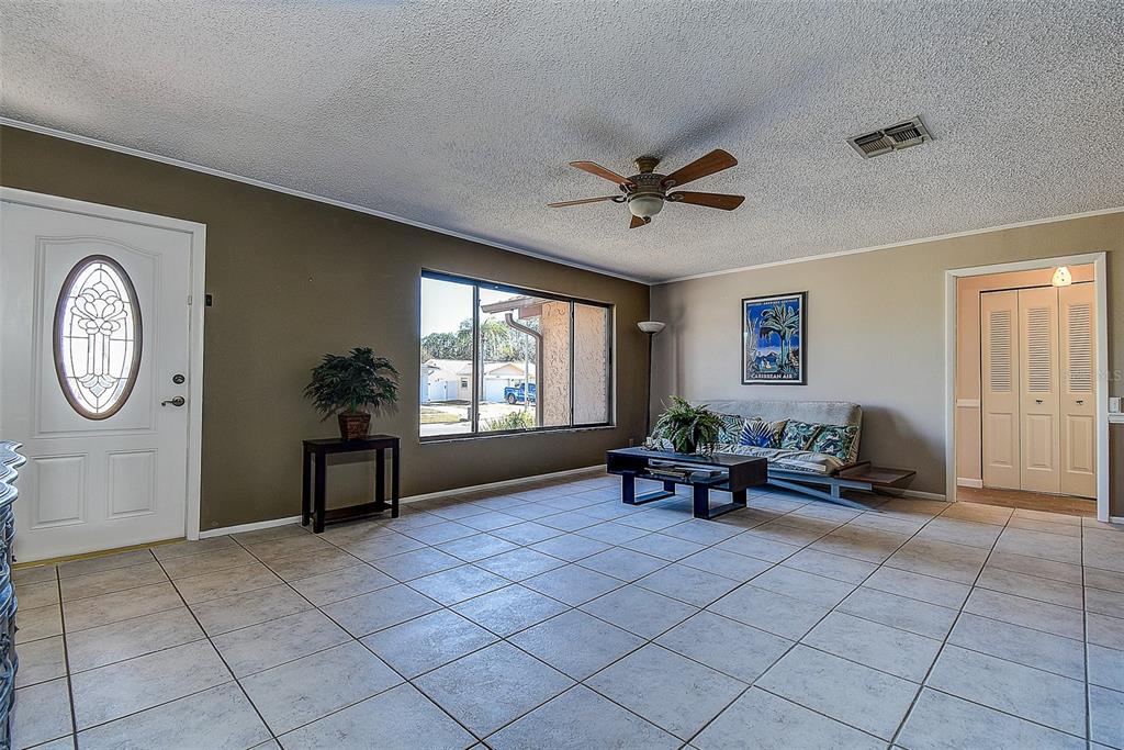 808 Helmsman Way Palm Harbor, FL 34685 - Photo 4 of 27 a living room with furniture a window and a clock