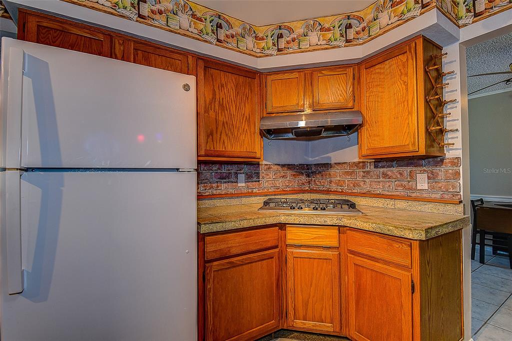 808 Helmsman Way Palm Harbor, FL 34685 - Photo 9 of 27 a kitchen with a refrigerator and a stove