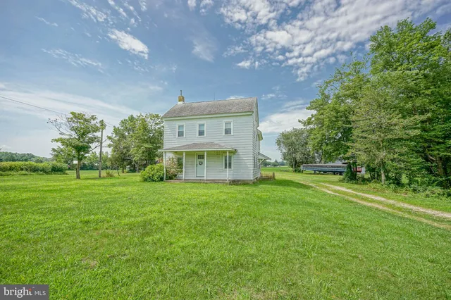 a view of a big house with a big yard and large trees