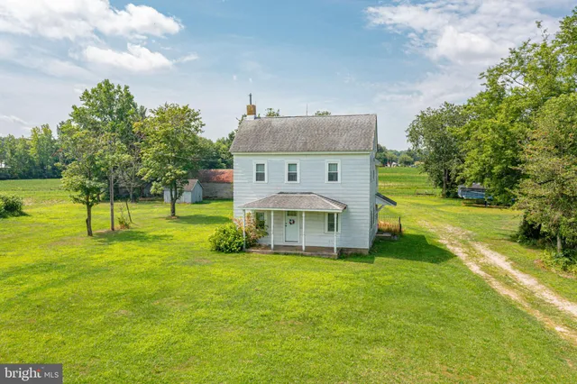 a view of a house with a big yard and large trees