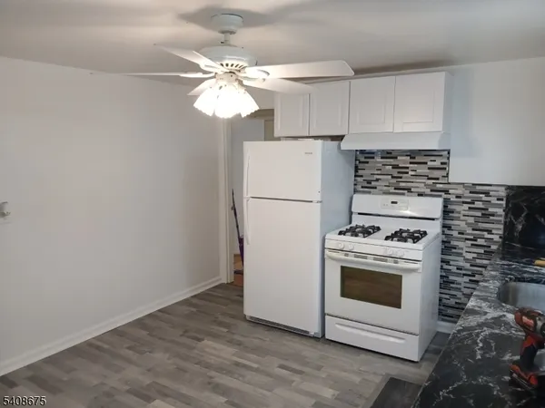 a kitchen with a stove refrigerator and white cabinets