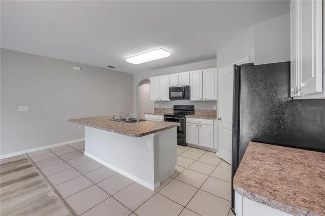 a living room with furniture a chandelier and a window