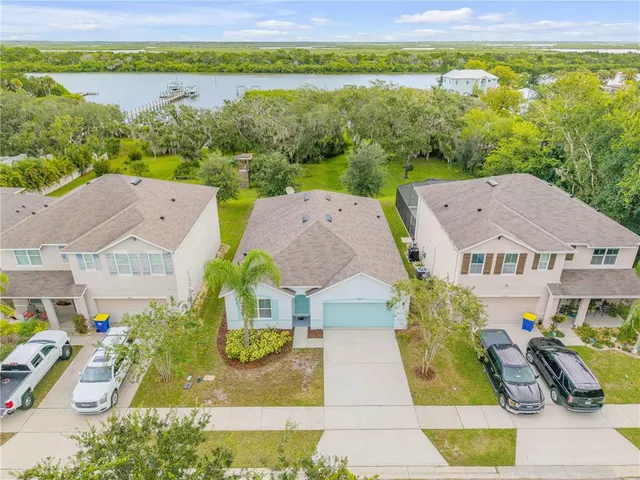 an aerial view of a house with a garden and lake view