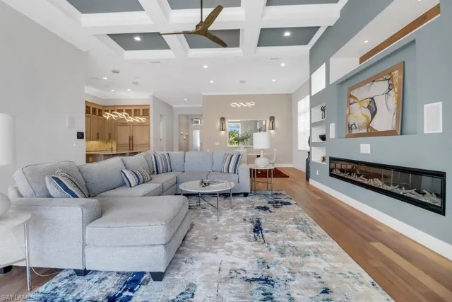 a bedroom with a large bed a chandelier and dresser