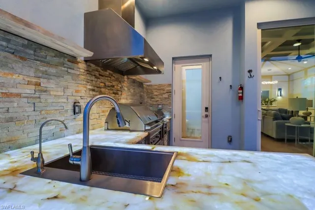 a kitchen with kitchen island granite countertop a table chairs sink and cabinets