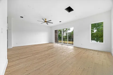 a view of an empty room with a window and a ceiling fan