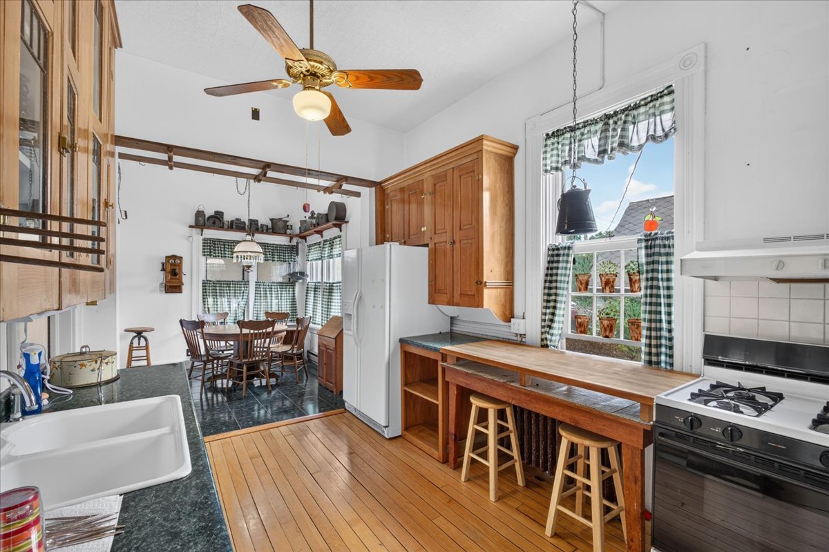622 North 7th Street Rochelle, IL 61068 - Photo 22 of 52 a kitchen with stainless steel appliances granite countertop a stove a refrigerator a dining table and chairs with wooden floor