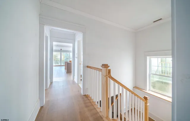 a view of a hallway with wooden floor and entryway