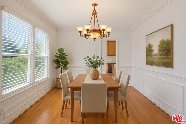 a dining room with furniture a large window and wooden floor