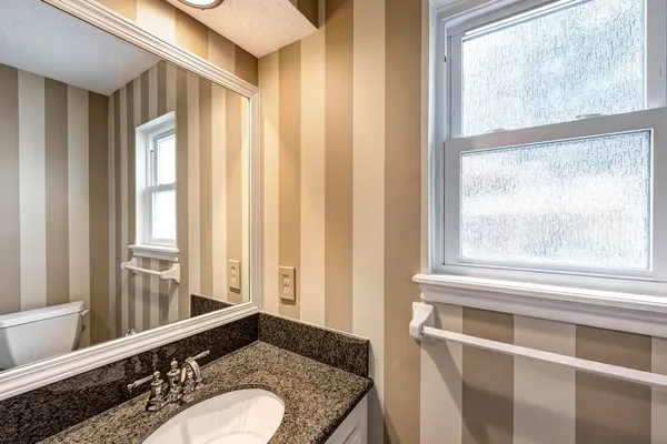 a bathroom with a granite countertop sink and a mirror