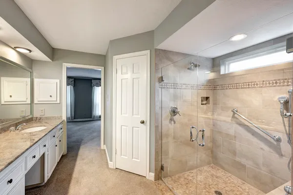 a spacious bathroom with a shower sink and mirror