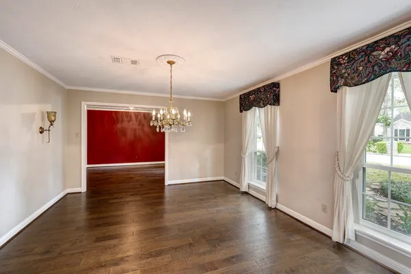 a view of a livingroom with wooden floor staircase and kitchen view