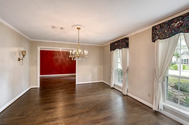a view of a livingroom with wooden floor staircase and kitchen view