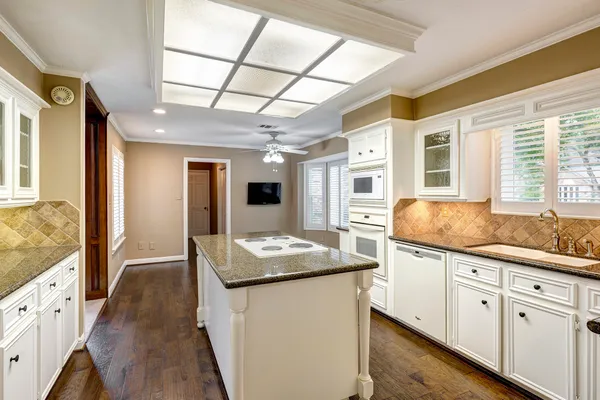 a kitchen with granite countertop a sink and a refrigerator