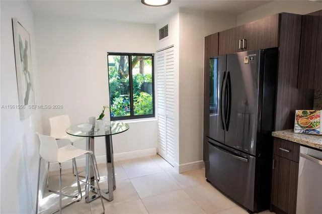 a metallic refrigerator freezer sitting in a kitchen