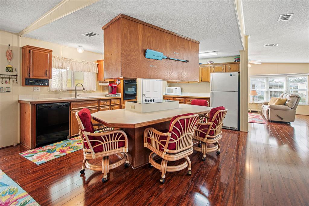 119 Mockingbird Lane Ellenton, FL 34222 - Photo 17 of 51 a dining room with stainless steel appliances a table and chairs with wooden floor
