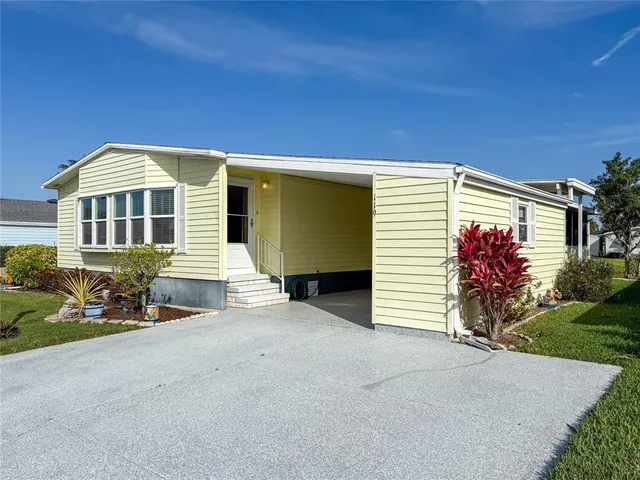 a view of a house with a yard and sitting area