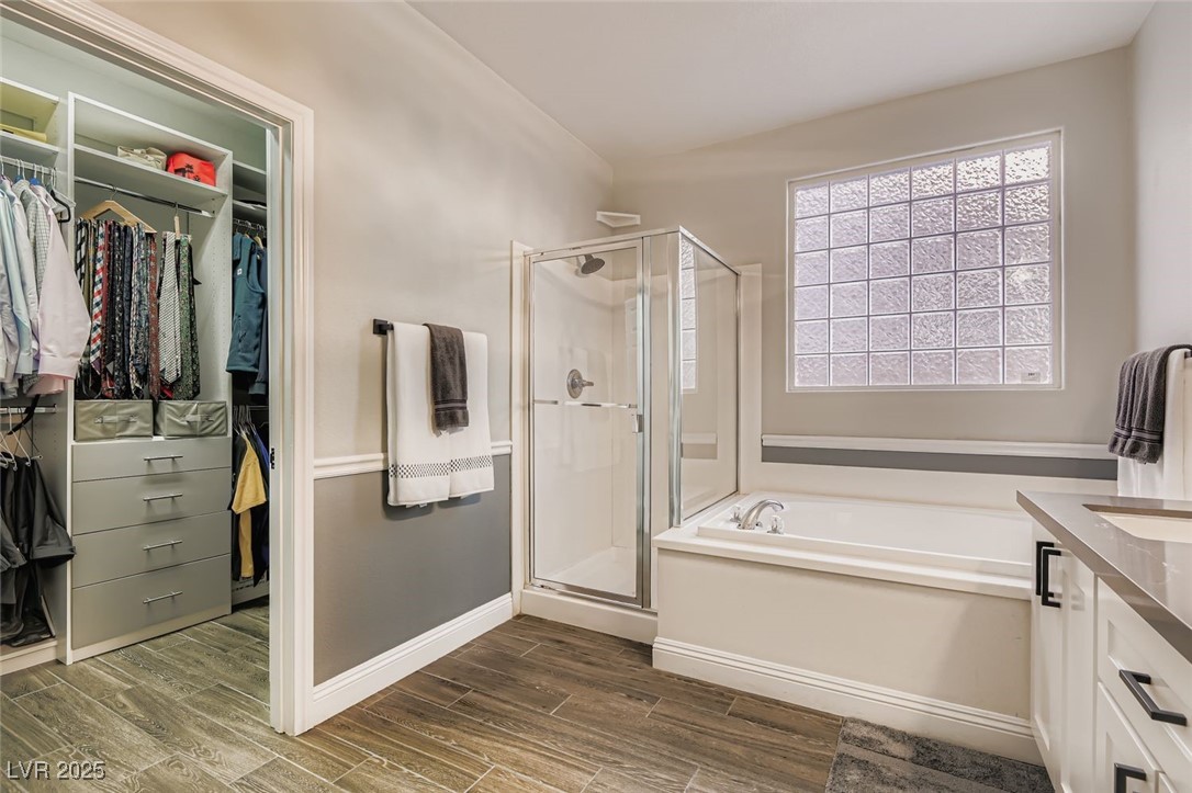 7055 Fort Tule Avenue Las Vegas, NV 89179 - Photo 18 of 75 Full bath featuring a walk in closet, vanity, a bath, tiled floors, and a shower stall, Molding trim all new vanity and faucets