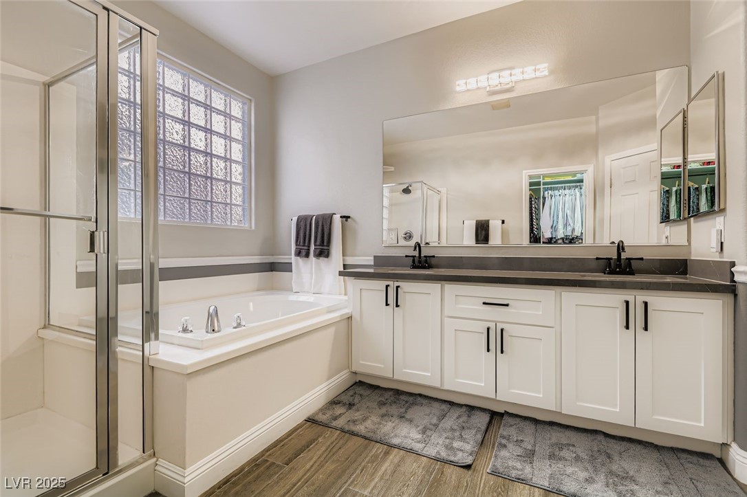 7055 Fort Tule Avenue Las Vegas, NV 89179 - Photo 19 of 75 Bathroom featuring a shower stall, a bath, double vanity, and a walk in closet black fixtures and custom lighting
