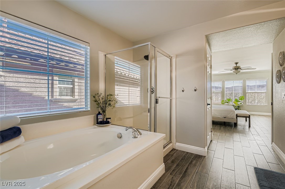 7055 Fort Tule Avenue Las Vegas, NV 89179 - Photo 30 of 75 2 primary up Ensuite bathroom with tile flooring, a stall shower, a garden tub,